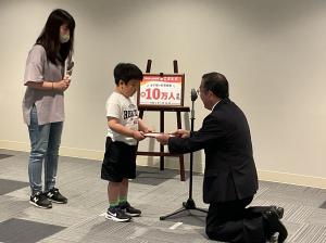 10万人目の認定証をお渡しする様子