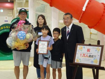 １万人目の利用者様ご家族と市長の記念写真